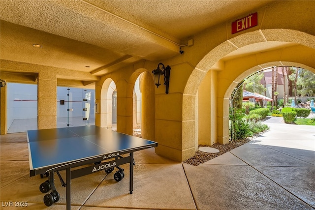 recreation room with a textured ceiling