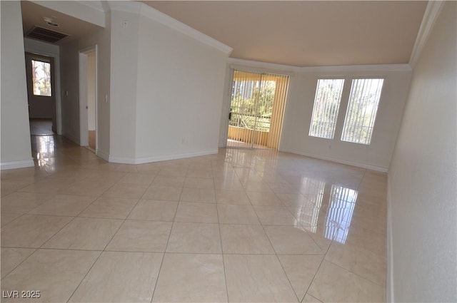 spare room featuring a healthy amount of sunlight, light tile patterned flooring, visible vents, and crown molding