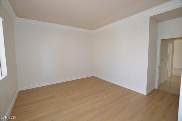 unfurnished room featuring light wood-type flooring, baseboards, and crown molding