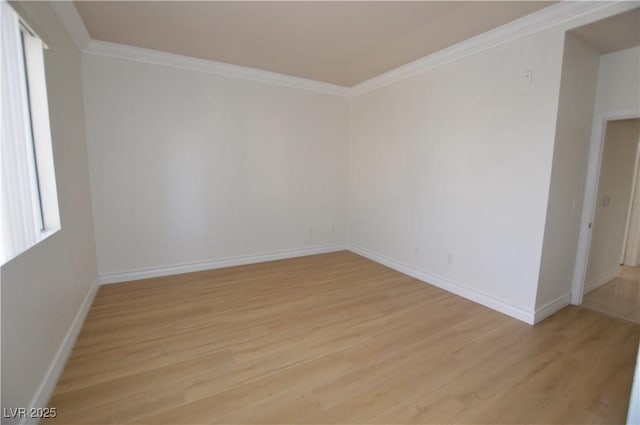 empty room featuring light wood-type flooring, baseboards, and crown molding