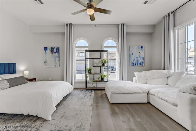 bedroom featuring multiple windows, ceiling fan, and wood-type flooring