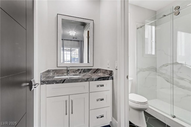 bathroom featuring tile patterned flooring, a shower with door, vanity, and toilet