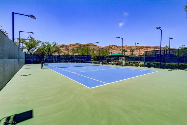 view of sport court featuring basketball hoop and a mountain view