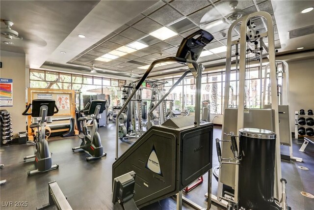 gym featuring a drop ceiling and ceiling fan