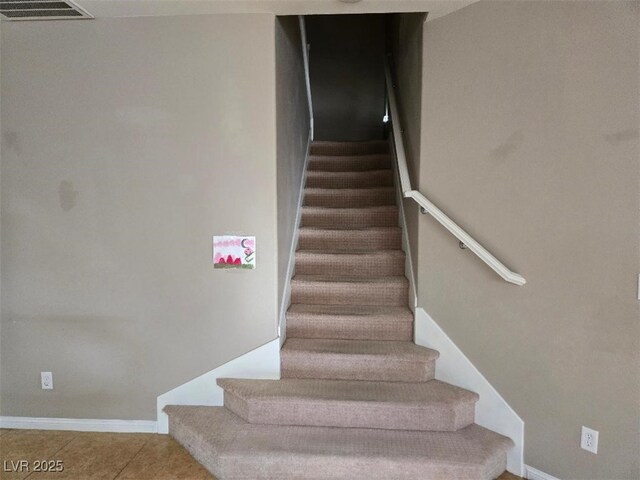 stairway featuring tile patterned flooring