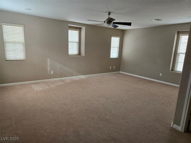 carpeted empty room featuring ceiling fan and a healthy amount of sunlight