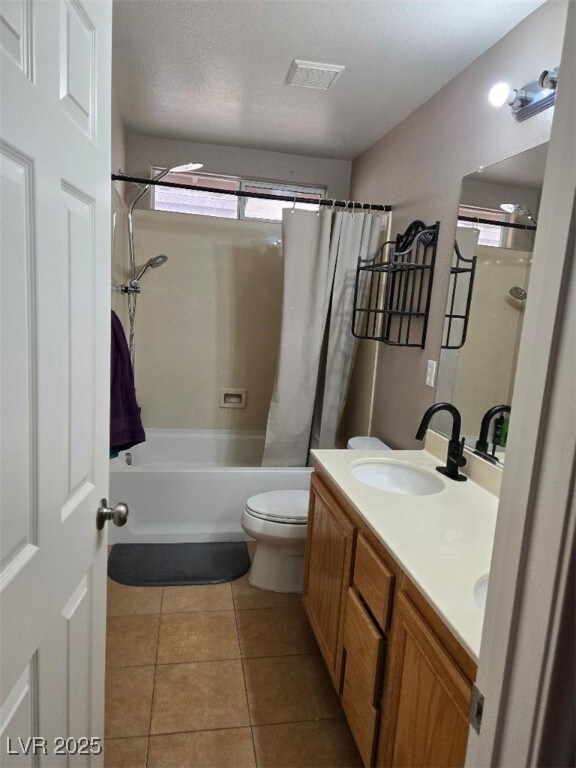 full bathroom featuring tile patterned floors, vanity, shower / bath combo, and toilet