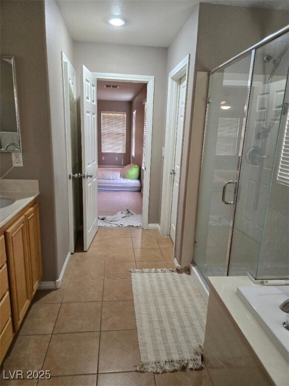 bathroom with tile patterned floors, vanity, and an enclosed shower