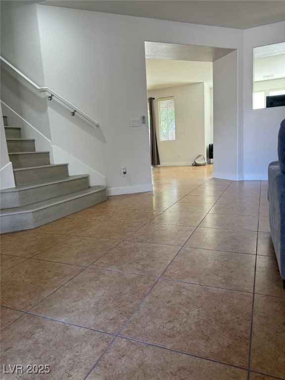 10046 Dancing Lasso Ct, Las Vegas, NV 89178 - unfurnished living room with stairs, baseboards, and tile patterned floors