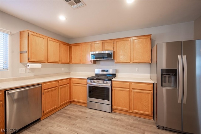 kitchen with light hardwood / wood-style floors and appliances with stainless steel finishes