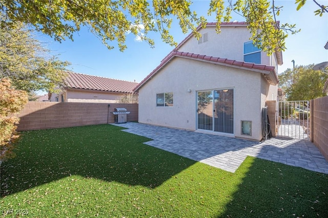 back of property with a yard and a patio area