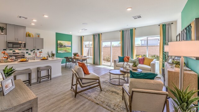 living room with light hardwood / wood-style floors and sink