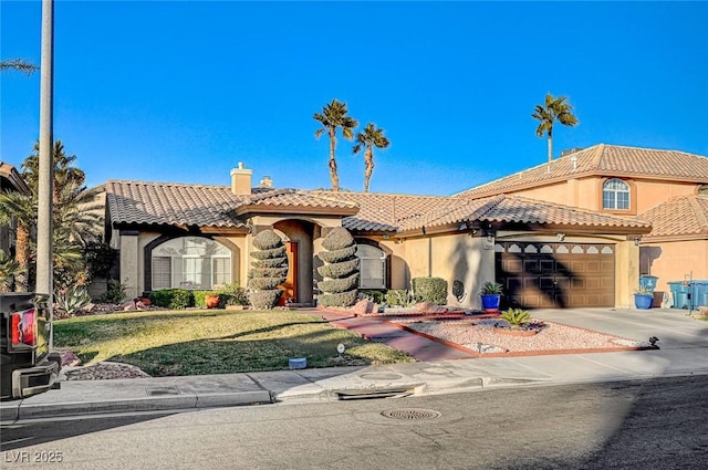 mediterranean / spanish house with a garage and a front yard