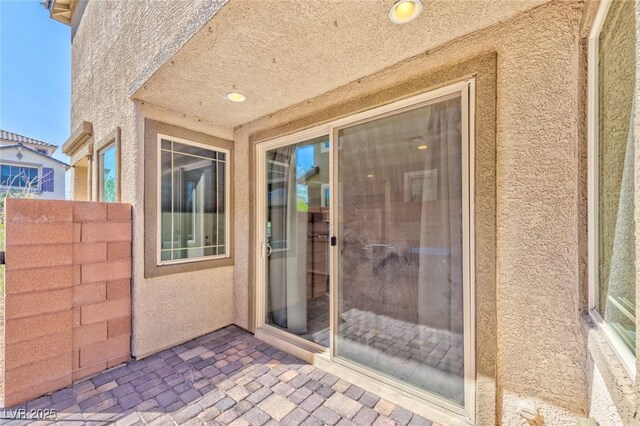 view of exterior entry featuring a patio