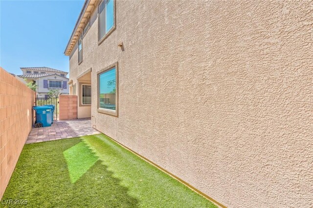 view of home's exterior with a patio area and a lawn