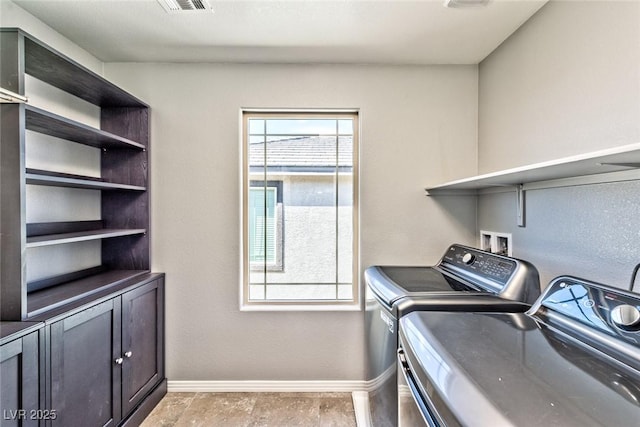 washroom with cabinet space, independent washer and dryer, and baseboards