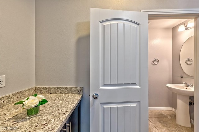 bathroom with baseboards and tile patterned flooring