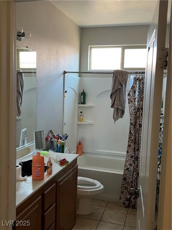 full bathroom featuring toilet, tile patterned floors, vanity, and shower / bath combo with shower curtain