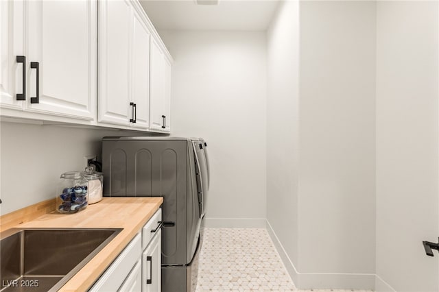 laundry area featuring cabinets, sink, and washing machine and clothes dryer