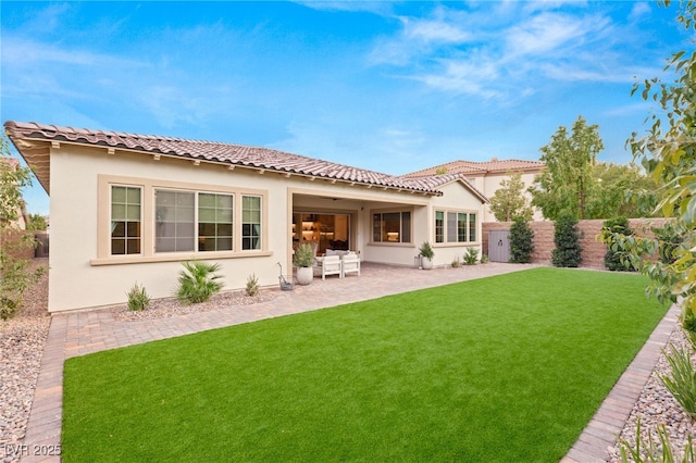 rear view of house featuring a patio area and a yard