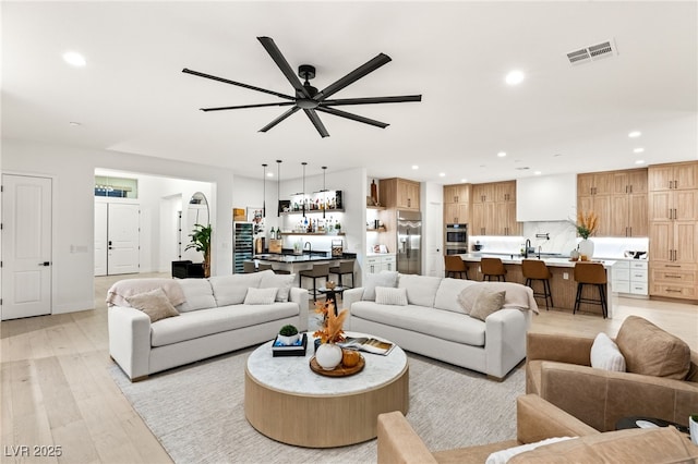 living room featuring ceiling fan and light hardwood / wood-style flooring