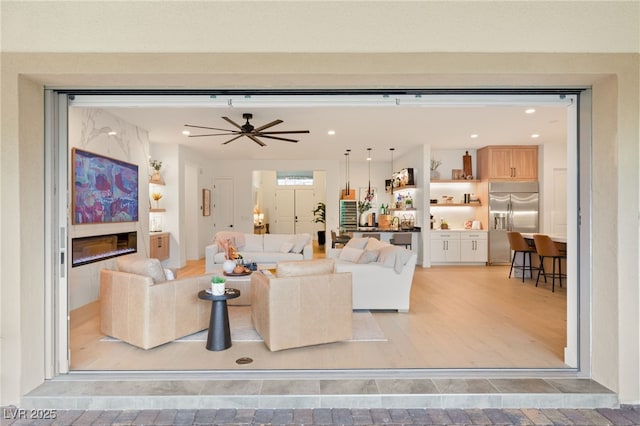 living room featuring ceiling fan and a premium fireplace