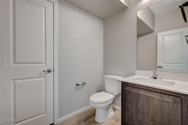 bathroom featuring wood-type flooring, vanity, and toilet