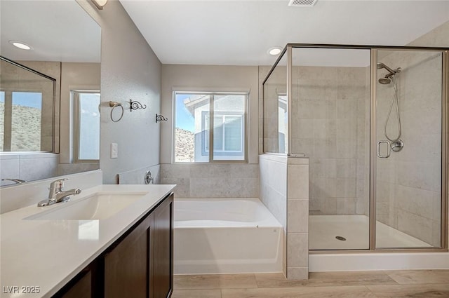 bathroom with vanity and separate shower and tub