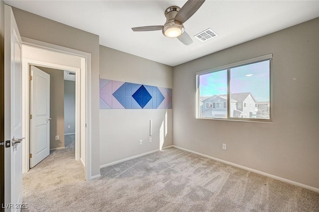 empty room with ceiling fan and light colored carpet