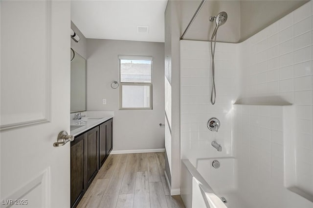 bathroom featuring hardwood / wood-style floors, vanity, and shower / bathtub combination