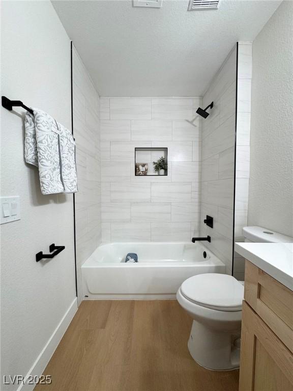 full bathroom with wood-type flooring, vanity, toilet, and tiled shower / bath