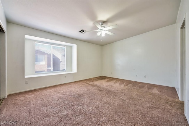 carpeted spare room featuring ceiling fan