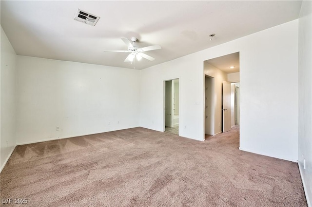 spare room featuring ceiling fan and light colored carpet