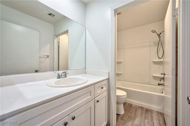 full bathroom with vanity, wood-type flooring, tub / shower combination, and toilet