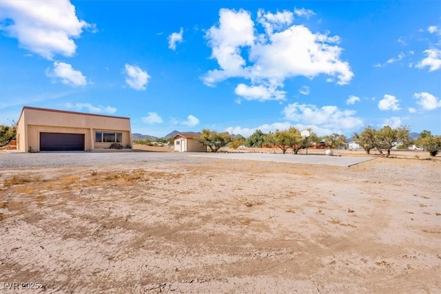 view of yard featuring a garage and an outbuilding