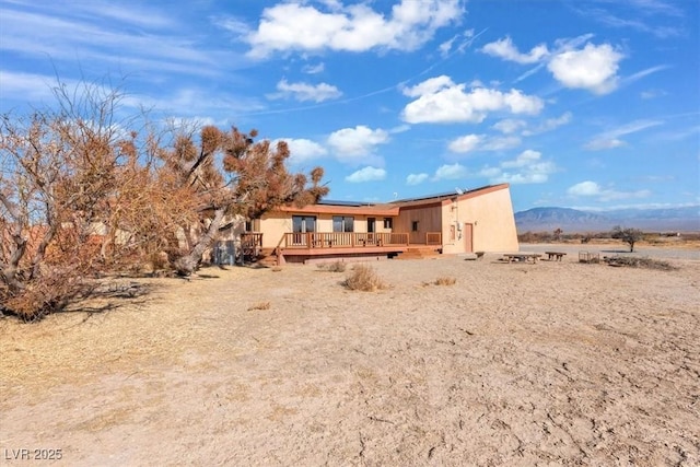 rear view of house with a deck with mountain view