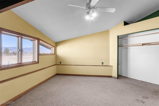 unfurnished bedroom featuring light carpet, a closet, vaulted ceiling, and ceiling fan