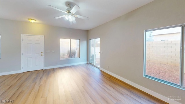 empty room with ceiling fan and light hardwood / wood-style floors