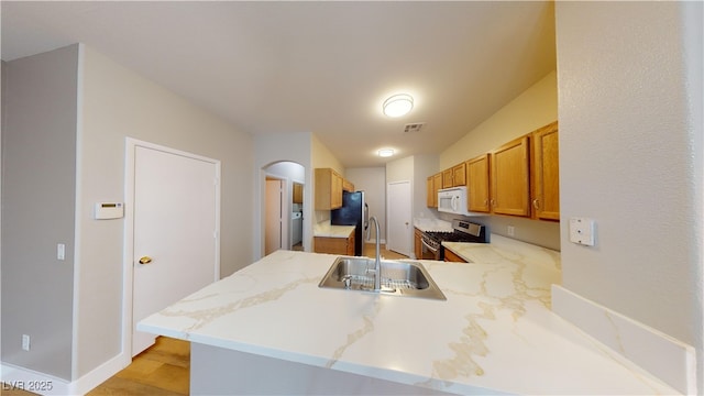 kitchen featuring kitchen peninsula, sink, and appliances with stainless steel finishes