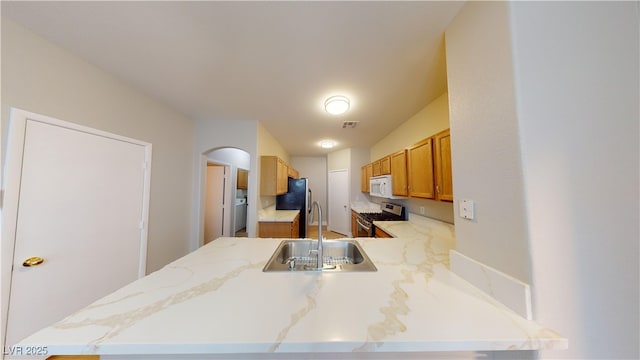 kitchen featuring kitchen peninsula, sink, and appliances with stainless steel finishes