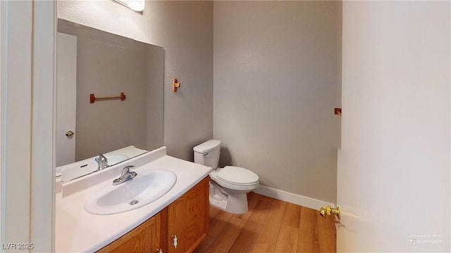 bathroom featuring toilet, vanity, and hardwood / wood-style flooring