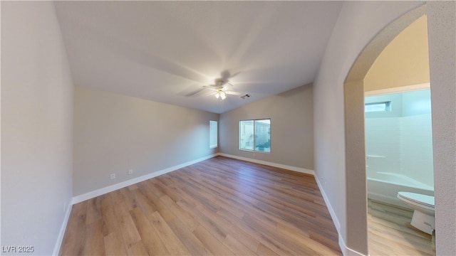 spare room with plenty of natural light, ceiling fan, light wood-type flooring, and lofted ceiling