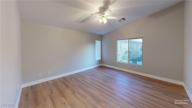 empty room with ceiling fan, lofted ceiling, and light wood-type flooring