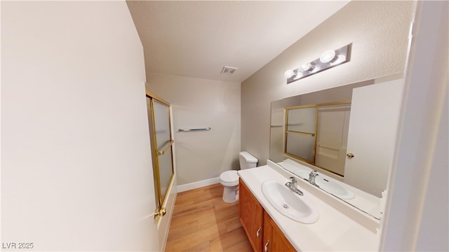 bathroom with hardwood / wood-style floors, toilet, an enclosed shower, and vanity