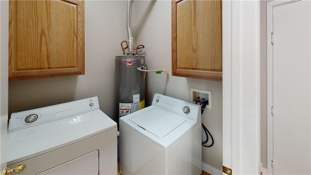 laundry room featuring water heater, cabinets, and washer and dryer