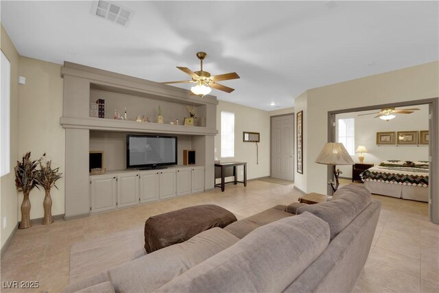 tiled living room with ceiling fan