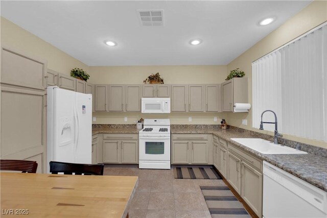 kitchen featuring sink, white appliances, and light tile patterned floors