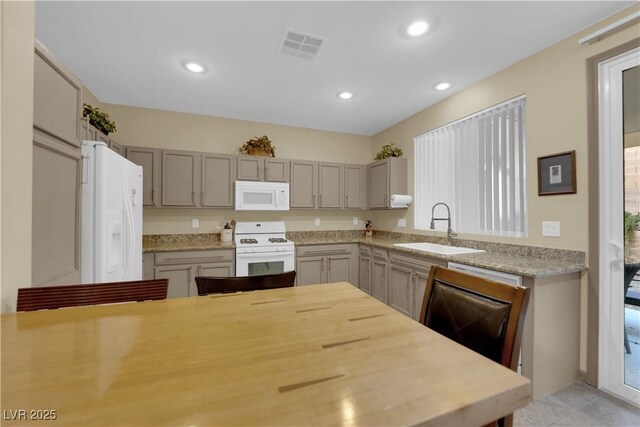 kitchen featuring sink, gray cabinetry, white appliances, and light tile patterned floors