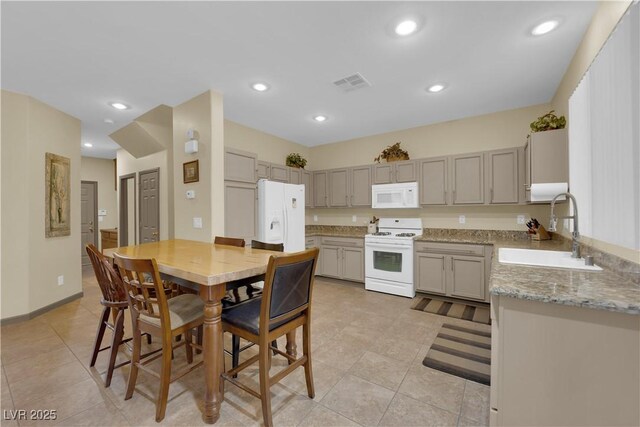 kitchen featuring gray cabinetry, sink, white appliances, and light stone counters