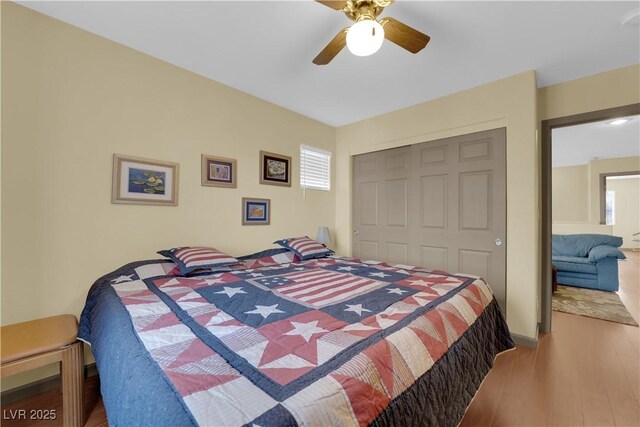 bedroom featuring hardwood / wood-style flooring, ceiling fan, and a closet